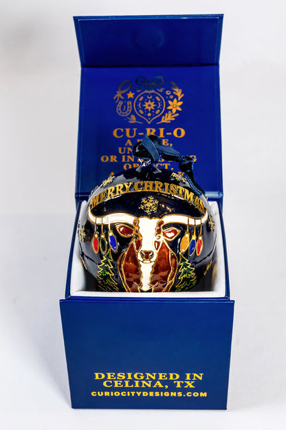 Celina longhorn Christmas scene on the reverse of the hand-painted glass ornament, presented in its blue CurioCity Designs gift box.