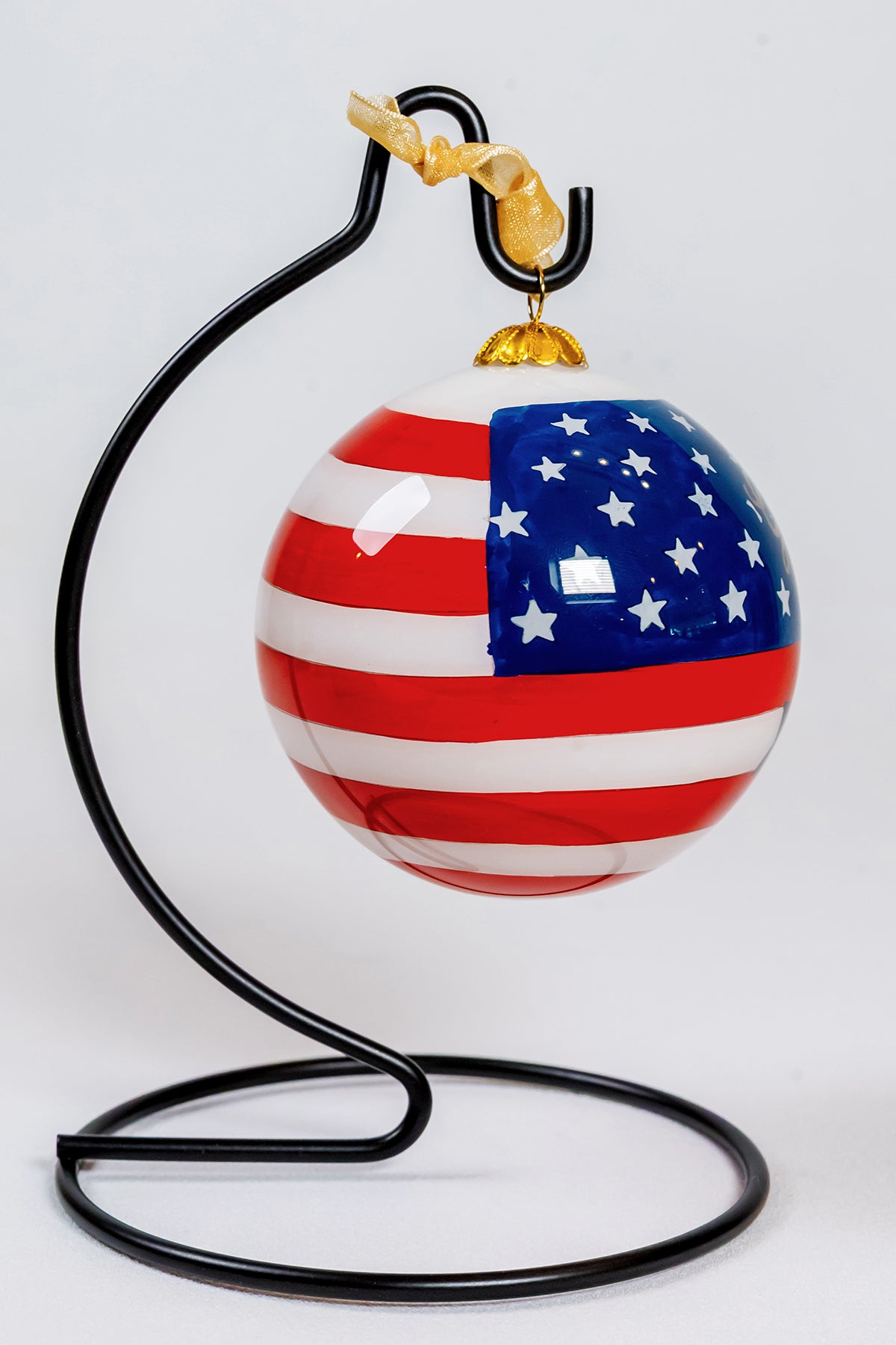 Reverse view of the USA 250 Years glass ornament hanging from a black ornament stand.