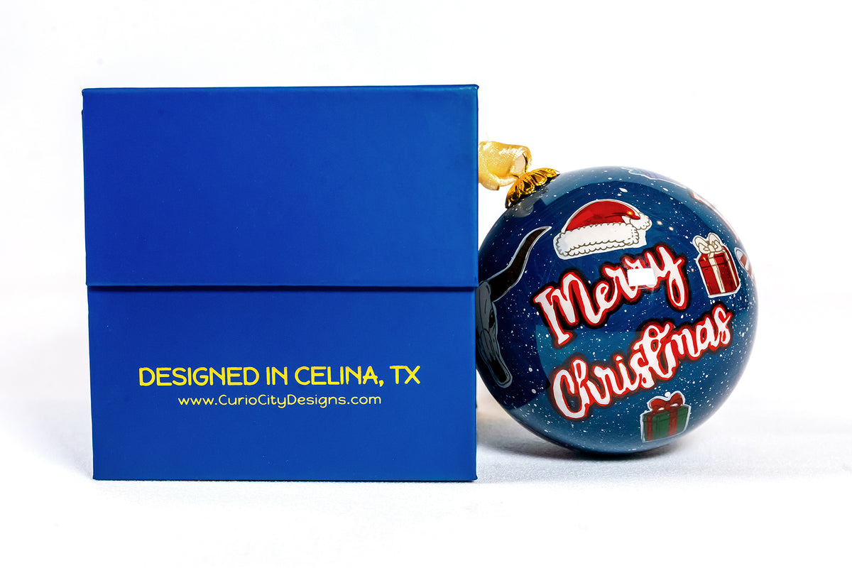 Prosper Texas hand-painted glass ornament with candy cane beside CurioCity Designs blue gift box