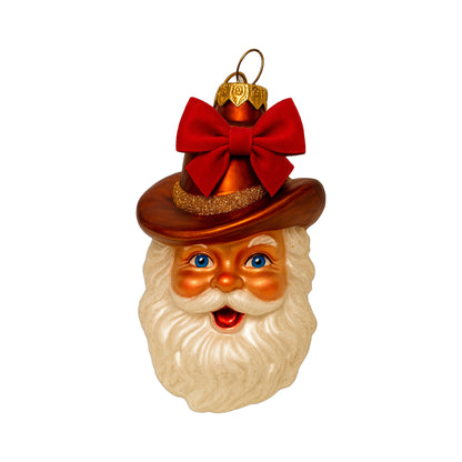 Vintage Cowboy Santa ornament with a brown cowboy hat, white beard and red bow on a white background.