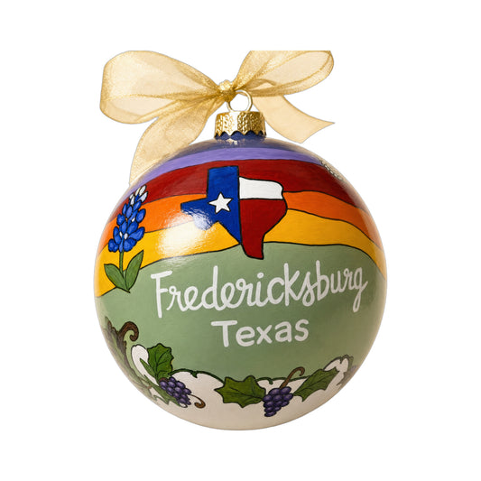 Fredericksburg Texas ornament with a Texas flag, bluebonnets, grapes and a gold ribbon.