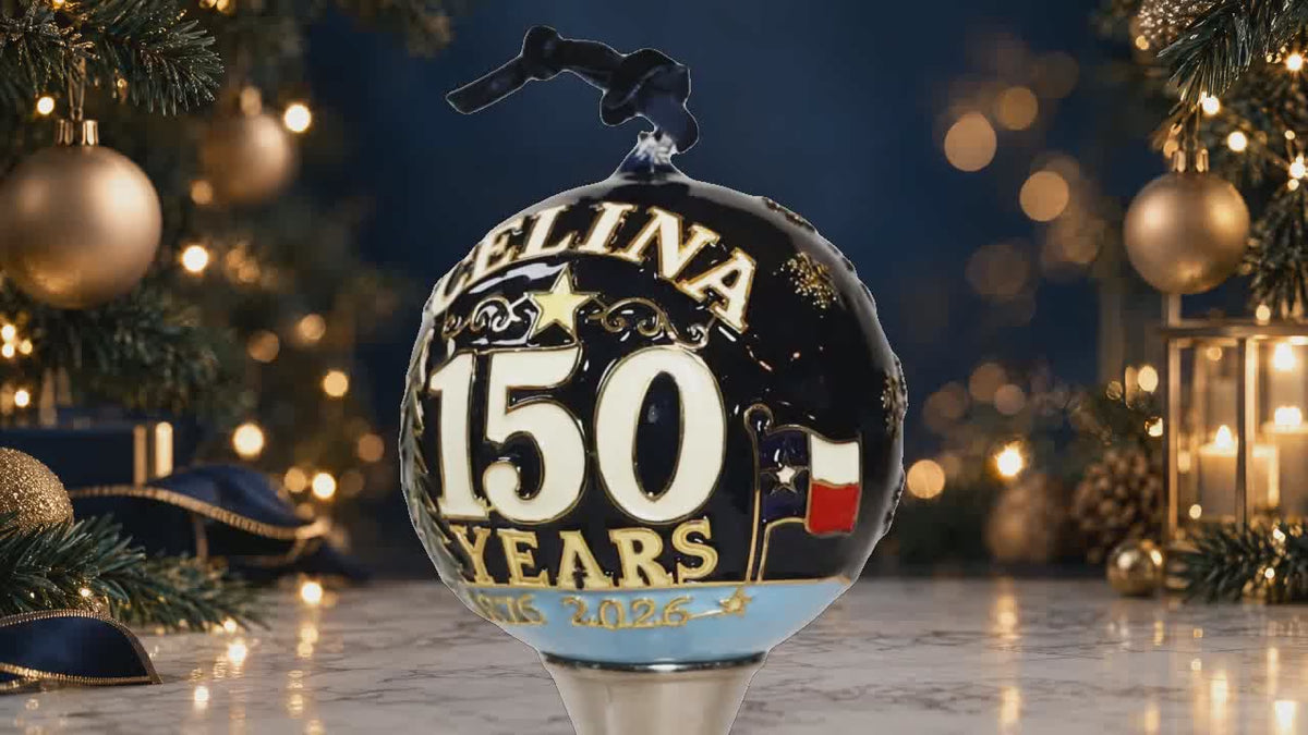 Rotating Celina 150th Anniversary hand-painted glass ornament with anniversary lettering and longhorn artwork against a luxury Christmas background.