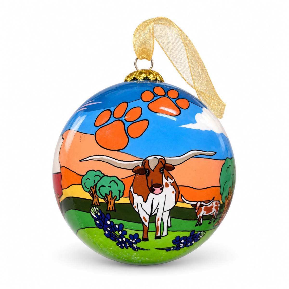Celina Sunsets and Longhorn glass ornament styled with a gold ribbon, showing a longhorn, bluebonnets, orange paw prints, and a Texas sunset.